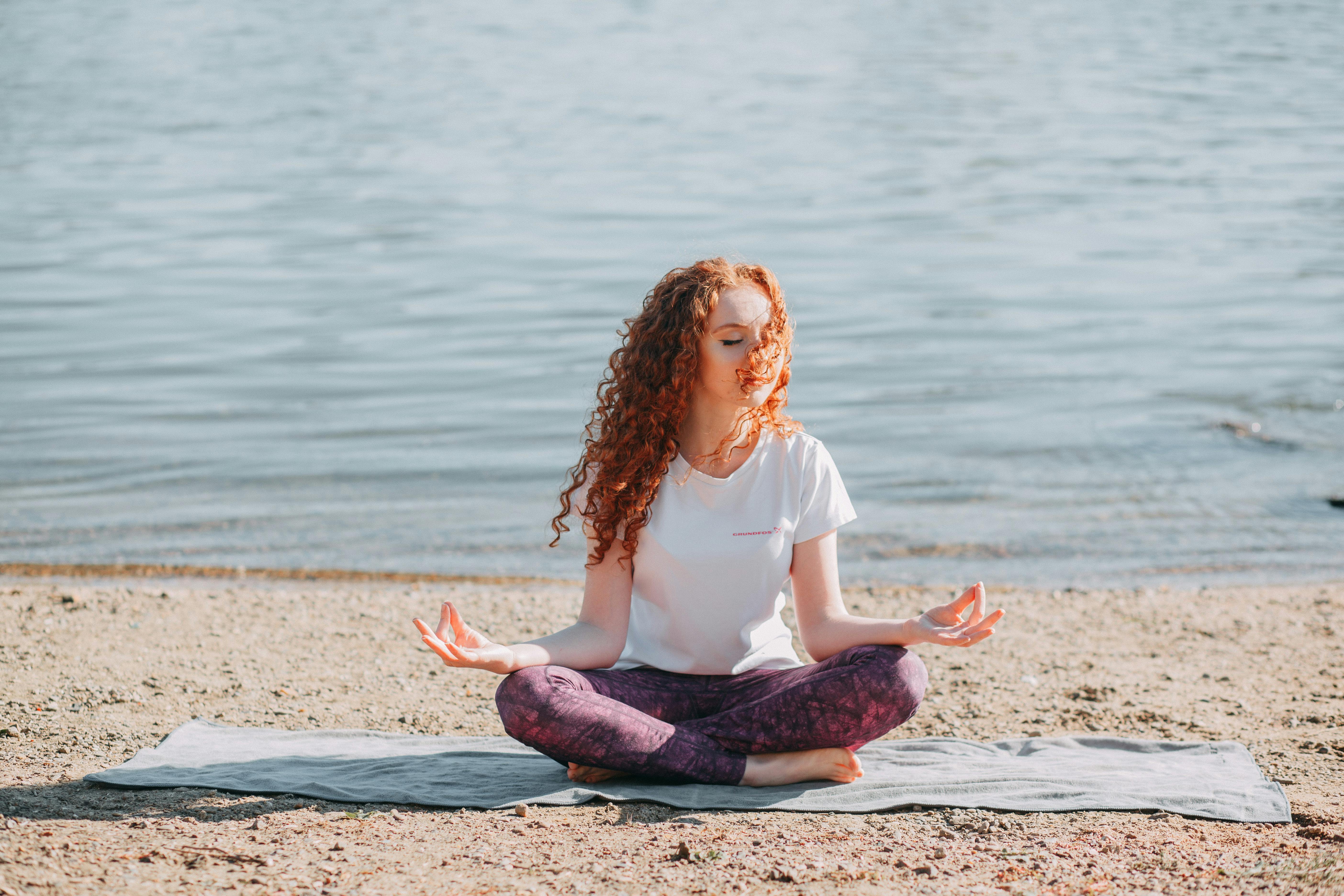 Woman doing yoga on the beach