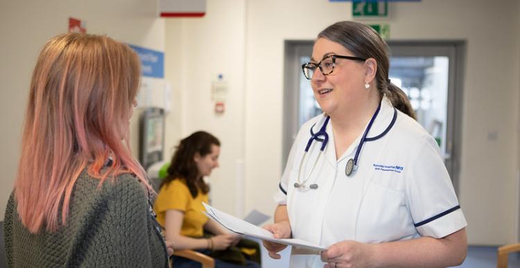 Nurse in a hospital talking to a patient