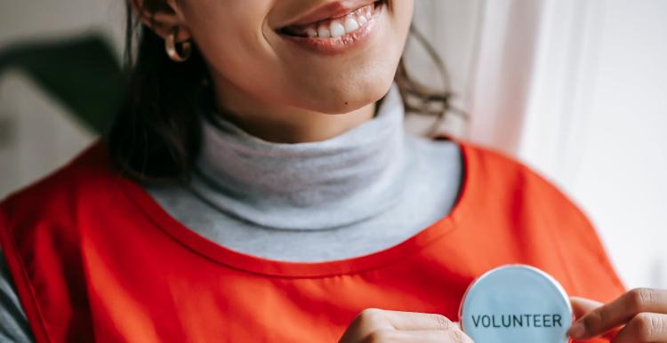 Woman with a volunteer badge on