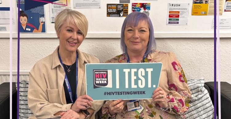 Photo of Andrea and Kym holding a 'I test' poster