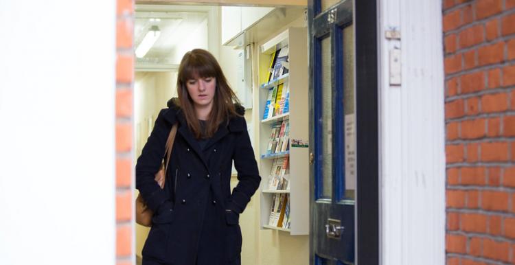 Young woman walking through a door deep in thought