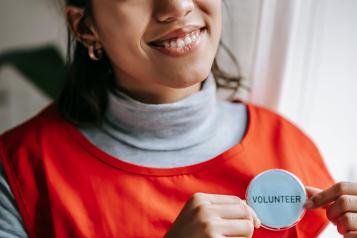 Woman with a volunteer badge on