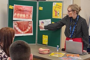 Leiann pointing to a picture showing tooth decay