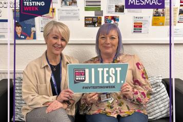 Photo of Andrea and Kym holding a 'I test' poster