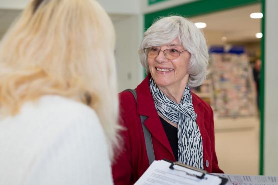 women smiling at a lady with a clipboard women smiling at a lady with a clipboard
